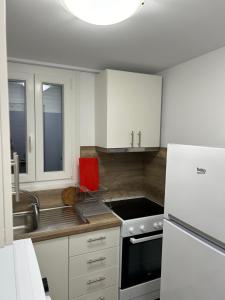 a kitchen with white cabinets and a stove top oven at Overwave Apartment in Kavála