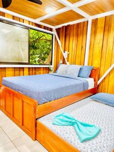 two beds in a room with a window at Villas Paraiso, Junquillal, Santa Cruz Desconectate en el Paraiso in Paraíso