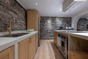 cocina con fregadero y pared de piedra en Exclusive 6 bed, 6 bath residence in Old Montreal en Montreal