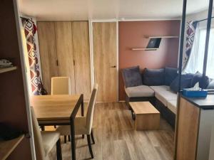 ein Wohnzimmer mit einem Sofa und einem Tisch in der Unterkunft 224 Emplacement prestige au Domaine de Kerlann 4* in Pont-Aven