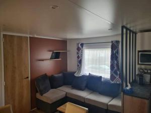 ein Wohnzimmer mit einem Sofa und einem Fenster in der Unterkunft 224 Emplacement prestige au Domaine de Kerlann 4* in Pont-Aven