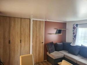 ein Wohnzimmer mit einem Sofa und einem Fenster in der Unterkunft 224 Emplacement prestige au Domaine de Kerlann 4* in Pont-Aven
