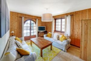 a living room with two couches and a table at Pretty nest with view of Mont Blanc in Combloux