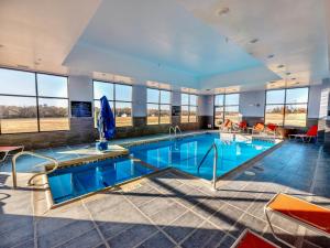- une piscine dans un hôtel doté d'une grande chambre avec fenêtres dans l'établissement Flag Point Inn and Suites Pratt, à Pratt