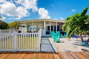 a house on the beach with a white fence at The Fisherman's Cottage in Key Colony Beach