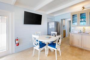 Key Colony Beach的住宿－The Fisherman's Cottage，一间配备有白色桌椅的用餐室