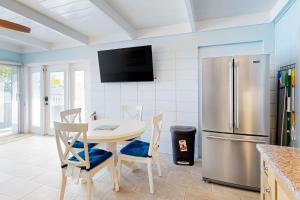 a kitchen with a table and a refrigerator at The Fisherman's Cottage in Key Colony Beach