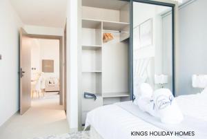 a bedroom with a white bed with a large mirror at binghatti canal , burj Khalifa view with private jacuzzi and cinema screen ,KINGS in Dubai