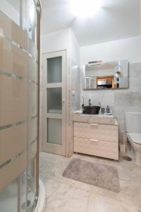 y baño con lavabo, aseo y espejo. en Elegante Atico Duplex, en Vigo