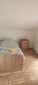 um quarto com uma cama e piso em madeira em Apartman Altina M em Zemun Polje