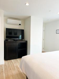 1 dormitorio con 1 cama y TV de pantalla plana en New Haven Inn, en Solvang