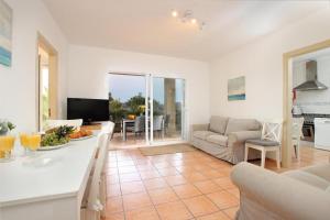 a kitchen and living room with a couch and a table at Villa Amoros in Alcudia