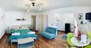 ロリカにあるCasa della montagna apartamentのベッドルーム1室(ベッド1台、青い椅子、テーブル付)