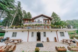 a house with a balcony on top of it at Casa della montagna apartament in Lorica