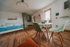 1 dormitorio con 1 cama, mesa y sillas en Casa della montagna apartament en Lorica