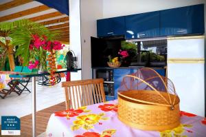 une cuisine avec une table et un panier dans l'établissement Gîtes Les Bienheureux - Piscine, Hamak, Terrasse, à Anse-Bertrand
