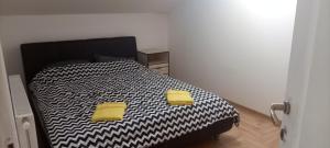 um quarto com uma cama preta e branca com almofadas amarelas em Apartman Altina M em Zemun Polje