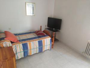 a bedroom with a bed and a flat screen tv at Habitacion Privada Doble en Toledo in Toledo