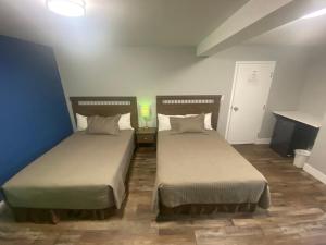 2 camas en una habitación con paredes azules en Alpha Inn, en Wawa