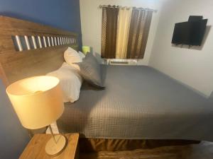 Dormitorio con cama, lámpara y lámpara en Alpha Inn en Wawa