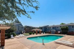 a swimming pool in a courtyard with chairs and condos at 2 Community Pools-Fully Stocked for Longer Stays in Mesa
