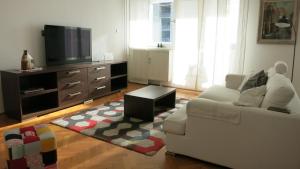 uma sala de estar com um sofá branco e uma televisão em Apartment Blessing em Zagreb