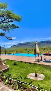a patio with a table and an umbrella next to a pool at Mirante Pai Inácio in Lençóis