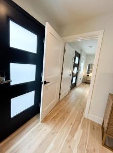 Habitación con puerta negra y suelo de madera. en New Haven Inn, en Solvang