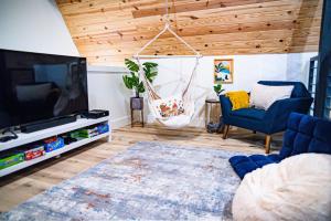 a living room with a large television and blue chairs at Gruene Daze Chalet - Stylish Aframe - Escape the Ordinary in New Braunfels