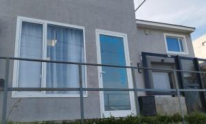 Una casa con una puerta azul a un lado. en Marejada en Comodoro Rivadavia