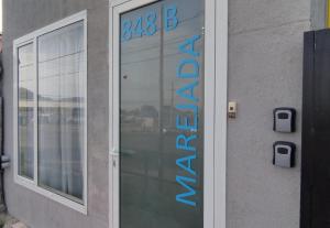 une porte menant à un bâtiment avec un panneau sur celui-ci dans l'établissement Marejada, à Comodoro Rivadavia