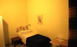 1 dormitorio con 1 cama y flores en la pared en Albergo Teatro, en La Spezia
