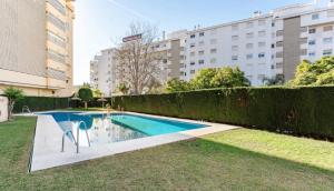 a swimming pool in the middle of a yard with buildings at Apartamento Boutique Miramar Playa, Garaje opcional in Fuengirola