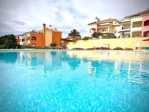 ein Swimmingpool mit blauem Wasser vor Häusern in der Unterkunft Espectacular dúplex in Murcia