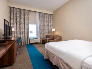 une chambre d'hôtel avec un lit et une télévision dans l'établissement Flag Point Inn and Suites Pratt, à Pratt