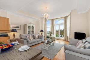 a living room with a couch and a table at Bryn Y Mor - Tenby Apartment Sea Views in Tenby