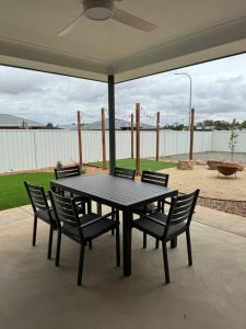 - une table et des chaises noires sur la terrasse dans l'établissement Modern luxury - Brand new home, à Parkes
