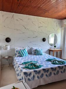 um quarto com uma cama grande com lençóis azuis e brancos em Mirante Pai Inácio em Lençóis