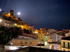 a view of a city at night with the moon at Pensione Sorriso in Vernazza