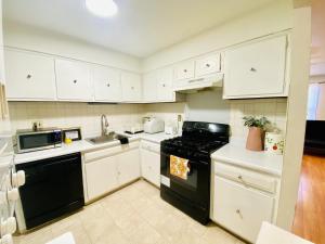 a kitchen with white cabinets and black appliances at Shanghai 2900 - Vintage Oriental Style 2BR w Parking near Airport in Philadelphia