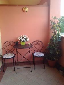uma mesa com duas cadeiras e uma mesa com flores em La Casa dell'Artista em Battifolle