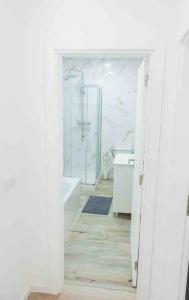 a white bathroom with a tub and a sink at Bright and modern flat with air-con and free parking in Moita