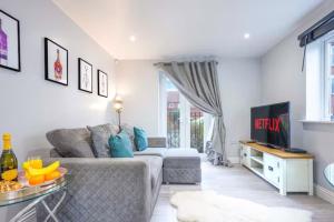 a living room with a couch and a table at Stylish Apartment - Close to the City Centre - Free Parking, Fast Wi-Fi and Smart TV with Netflix by Yoko Property in Aylesbury
