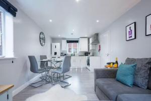 a living room with a couch and a kitchen at Stylish Apartment - Close to the City Centre - Free Parking, Fast Wi-Fi and Smart TV with Netflix by Yoko Property in Aylesbury