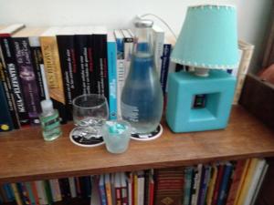 stół z lampką i butelką na półce z książkami w obiekcie Acogedora Habitación w mieście Santiago
