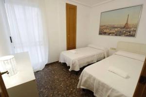 a room with two beds and a window at Playa Malvarrosa House in Valencia