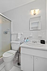 bagno bianco con servizi igienici e lavandino di Citrus Isles Waterfront Home a Fort Lauderdale