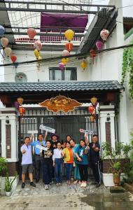 grupa ludzi stojących przed budynkiem w obiekcie Huế Thơ Homestay w mieście Hue