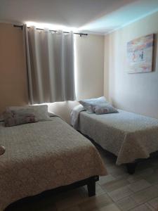 a bedroom with two beds and a window at Espectacular Depto Laguna Vista Algarrobo (3D2B) in Algarrobo