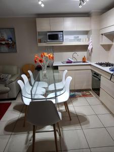 cocina con mesa de cristal y sillas blancas en Espectacular Depto Laguna Vista Algarrobo (3D2B), en Algarrobo